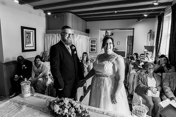 Couple weds in intimate ceremony room, guests present