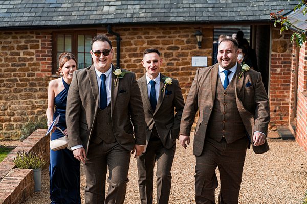 Group in suits and dresses outside brick building.