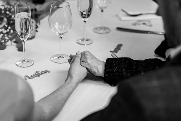 Couple holding hands at a table setting