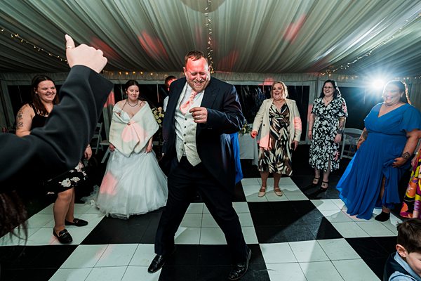 Guests dancing at wedding reception in marquee