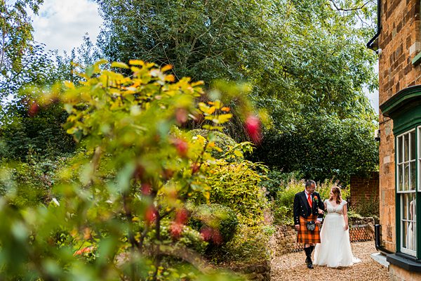 Bride and groom walking in a garden path