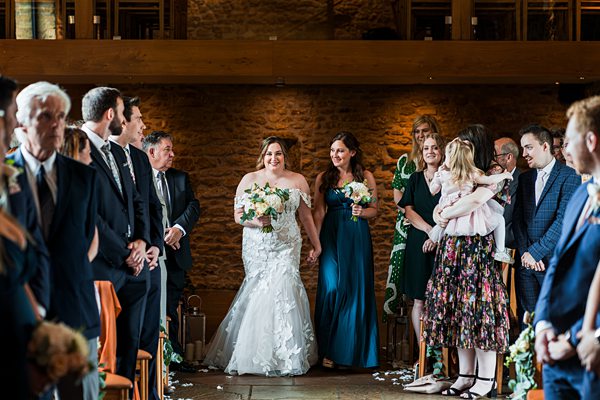 Brides walking down the aisle at wedding ceremony.