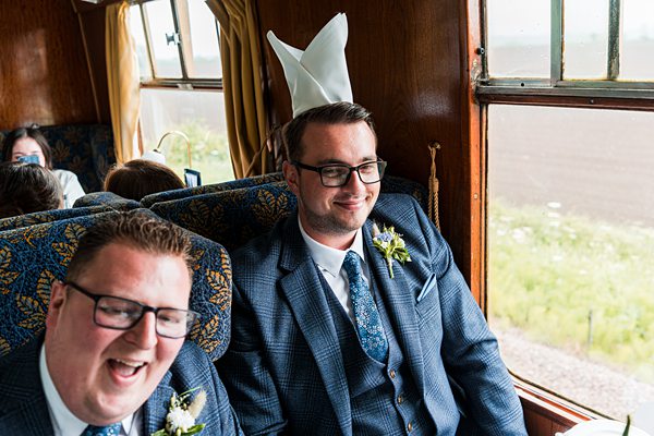Men in suits on a train laughing together.