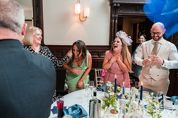 People laughing at a wedding reception table.
