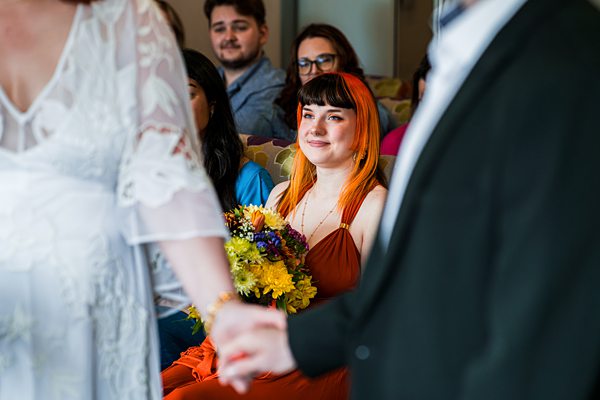 Wedding ceremony with guests and floral bouquet.