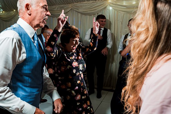 People dancing joyfully at a wedding reception.