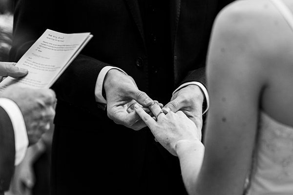 Couple exchanging rings at wedding ceremony.