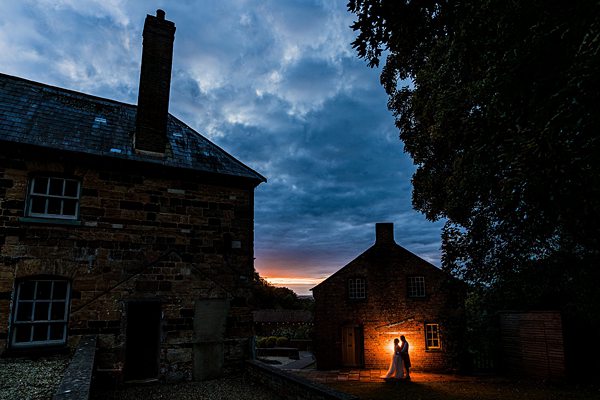 Silhouetted couple at twilight in rustic setting.