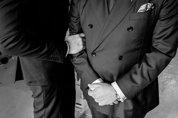 Two men in suits, showing formal attire details.