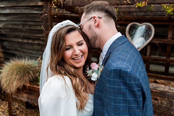 Bride and groom laughing outdoors