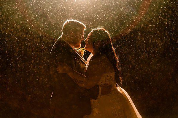 Romantic couple dancing in the rain at night.
