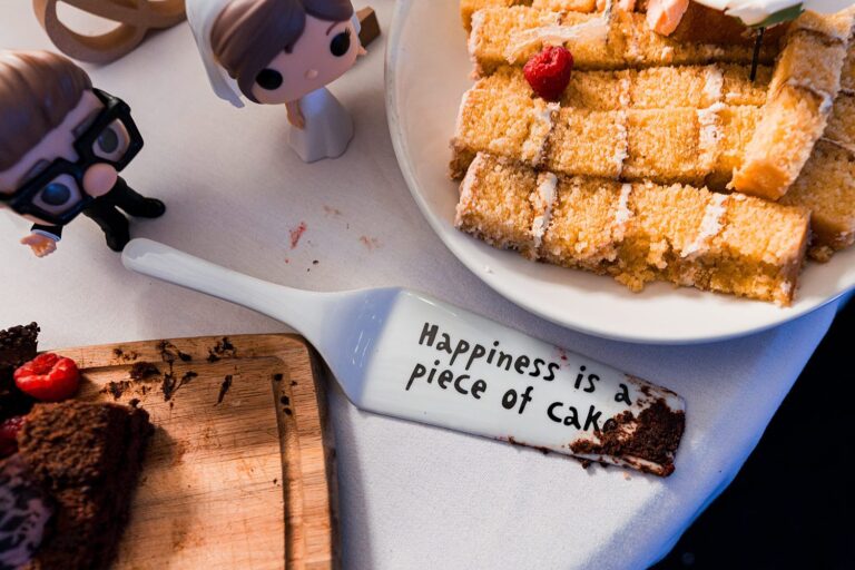 Cake slices with wedding figurines on table.
