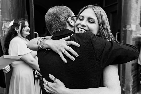 Two people hugging joyfully at a celebration.