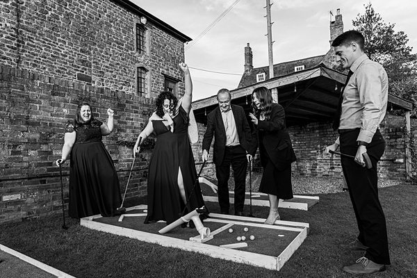 Group playing mini golf at event venue outdoors.