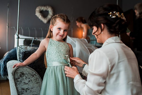 Woman adjusting girl's dress before event.