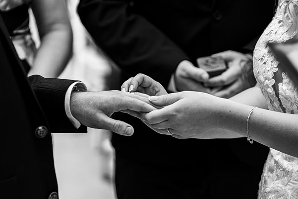 Couple exchanging rings during wedding ceremony.