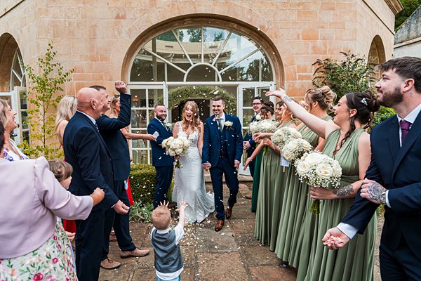 Bride and groom surrounded by celebrating guests.