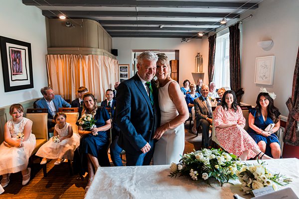 Wedding ceremony with smiling couple and guests.