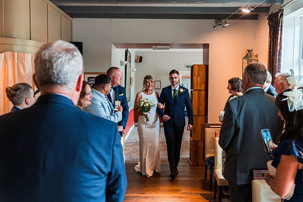 Bride walking down the aisle at wedding ceremony.
