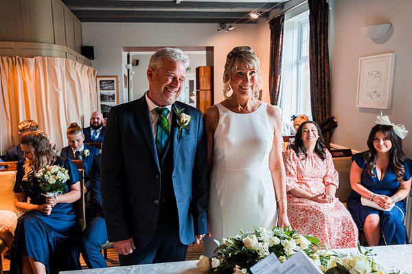 Couple at wedding ceremony with guests seated.