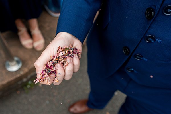Person holding confetti in hand at a wedding.
