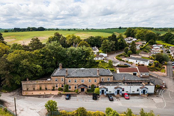 Aerial view of country hotel and surrounding landscape.