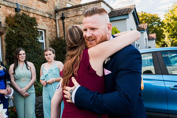 Man and woman hugging at outdoor event.