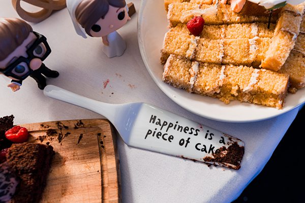 Wedding cake slice with happiness message on plate.