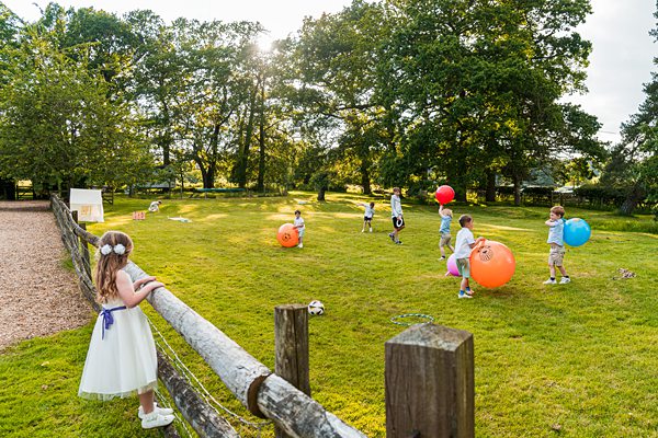 Children playing with balls in sunny field
