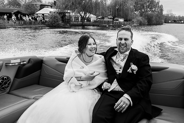 Bride and groom laughing on a boat ride.