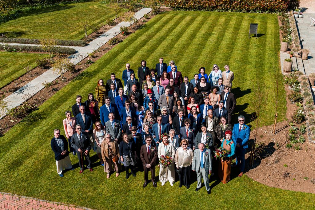Large group gathered in garden for a wedding.