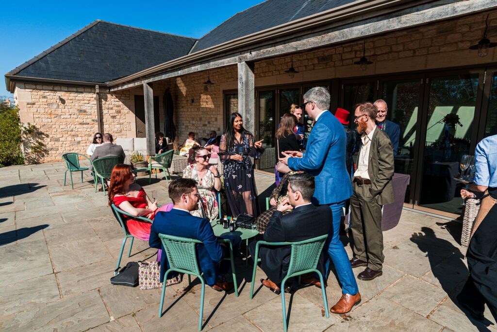 Outdoor gathering at modern stone building terrace.