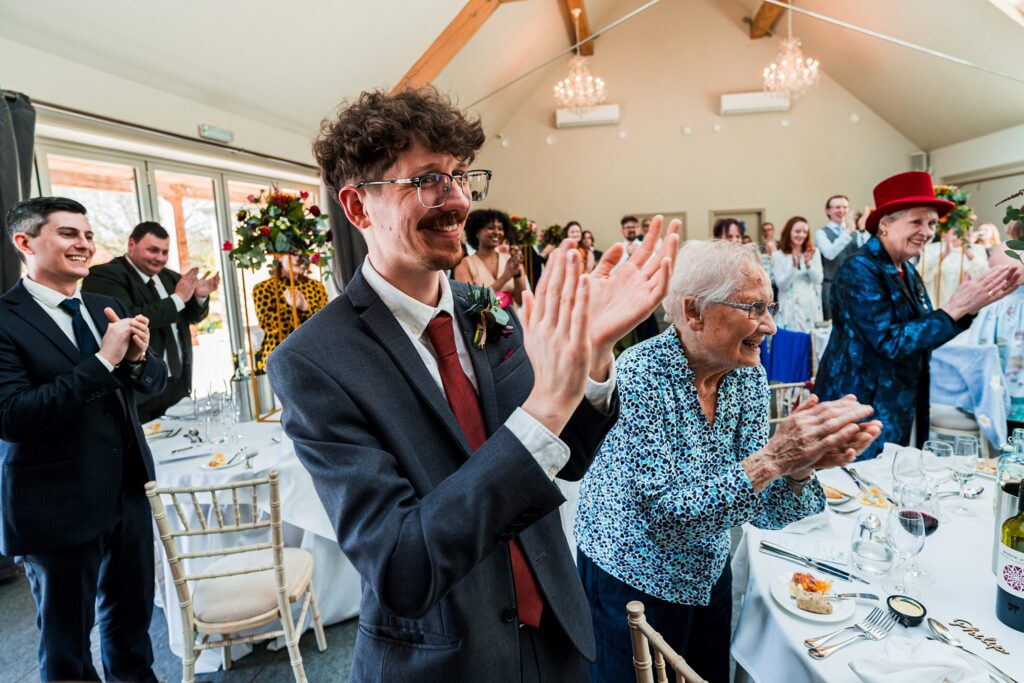 People clapping at a wedding reception.