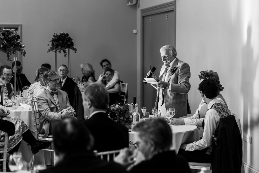 Elderly man giving speech at formal event.