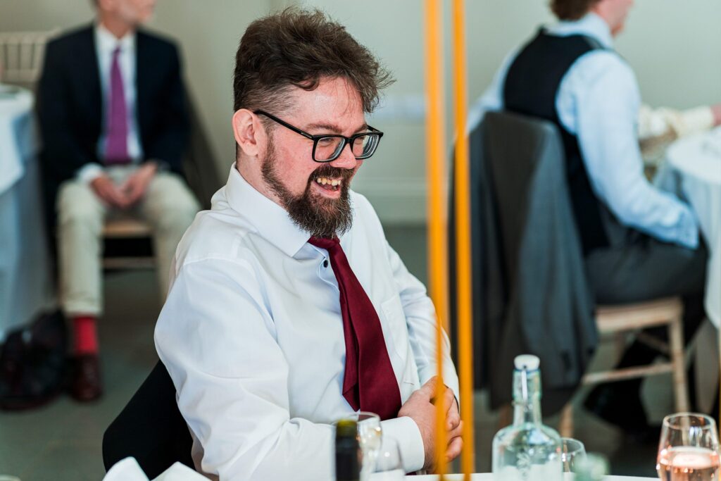Smiling man in red tie at formal event.