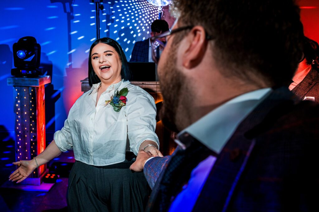 People dancing at a vibrant party with lighting.