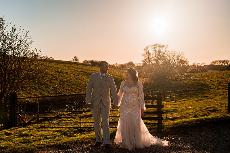 Couple walking hand in hand at sunset.