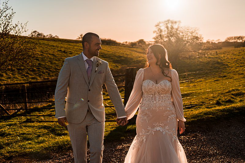 Couple walking hand in hand at sunset.